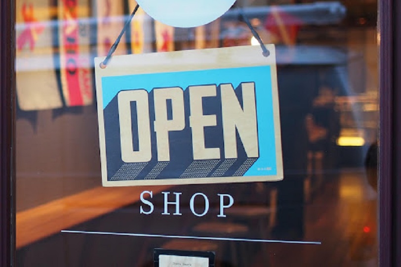 A picture of an open sign on the window of a shop.