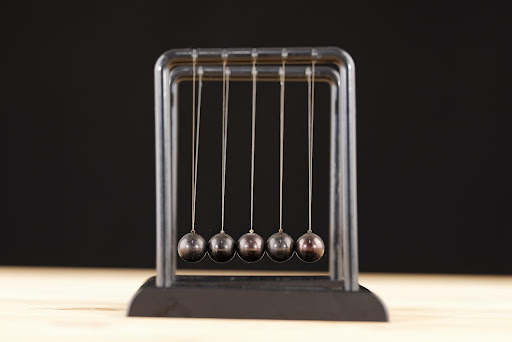 A picture of Newton’s Cradle to help demonstrate the effect that one action will have on a community.